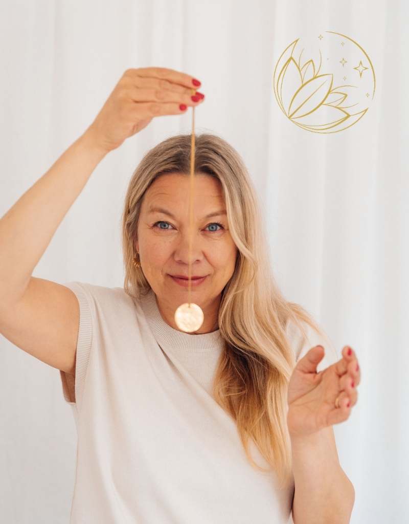 Ruth Mitchell Wealth Embodiment Expert Dorchester holding a gold pendulum during a Clear Energy Therapy session